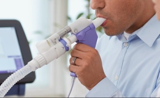 persona soplando en un espirómetro, guiado por un Doctor